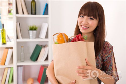 Young woman shopping for food, vegetables, fruits, oranges, grapes, and home goods_16323494_xxl
